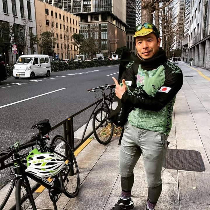 街中で自転車と写る木代 雅彦さん