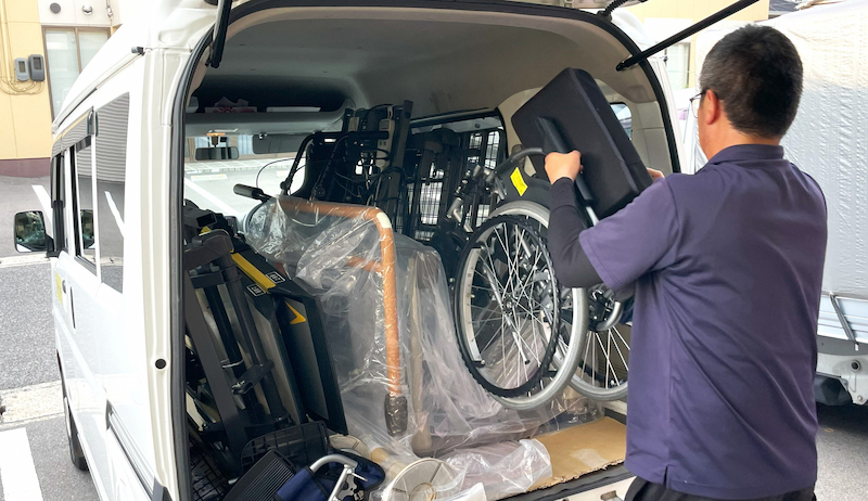 軽貨物車に男性が荷物を運び入れているイメージ
